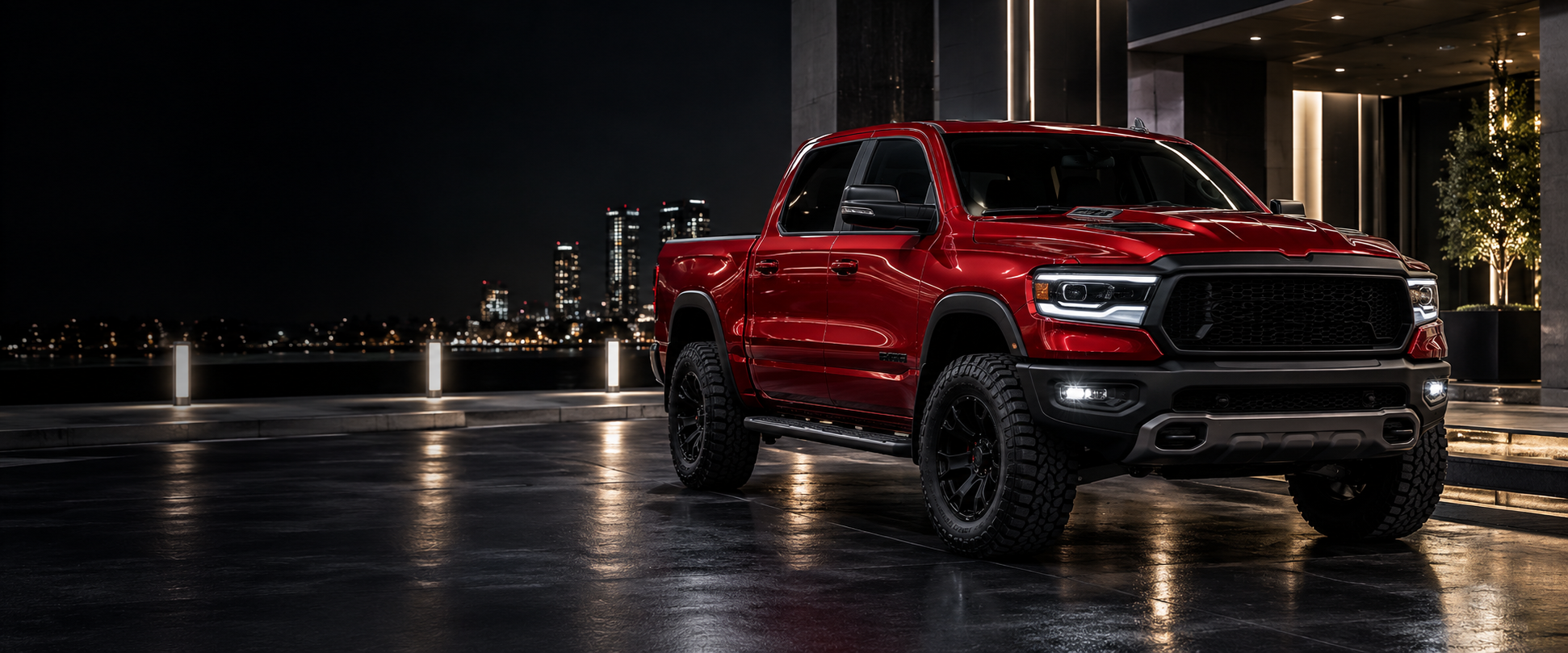 A premium red lifted pickup at a city curb at night